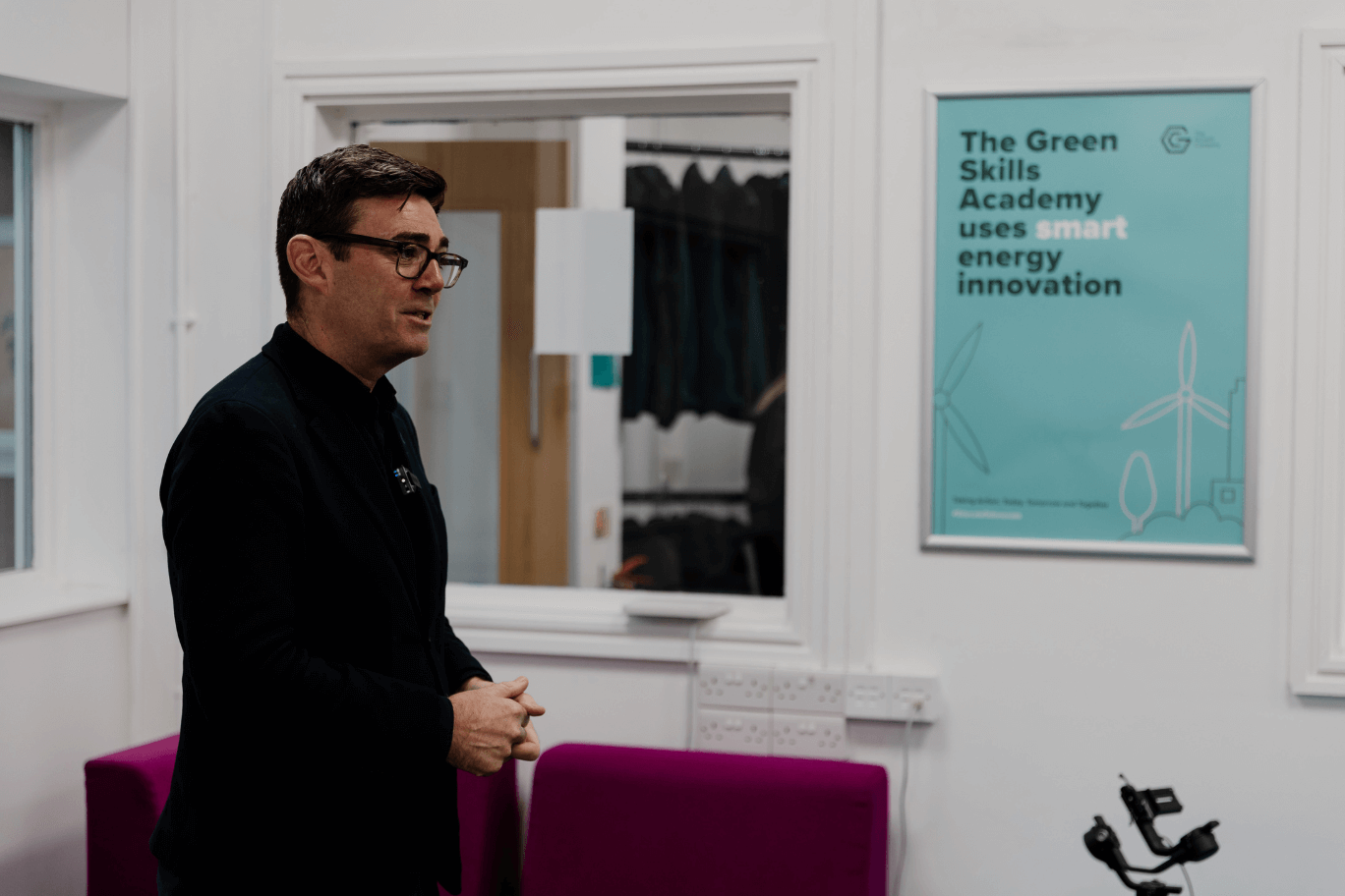 Mayor of GM Andy Burnham attends the Green Skills Academy event, standing in front of a poster