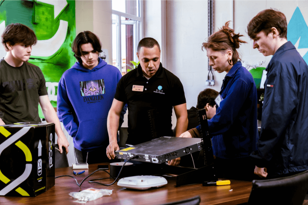 A group of students working on networking gear.