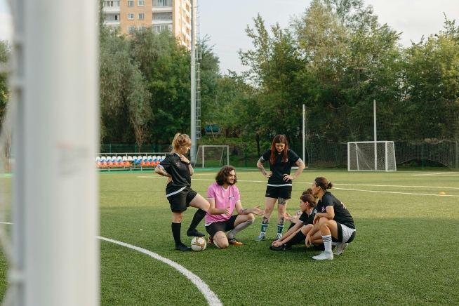 a group of women being coached to play football