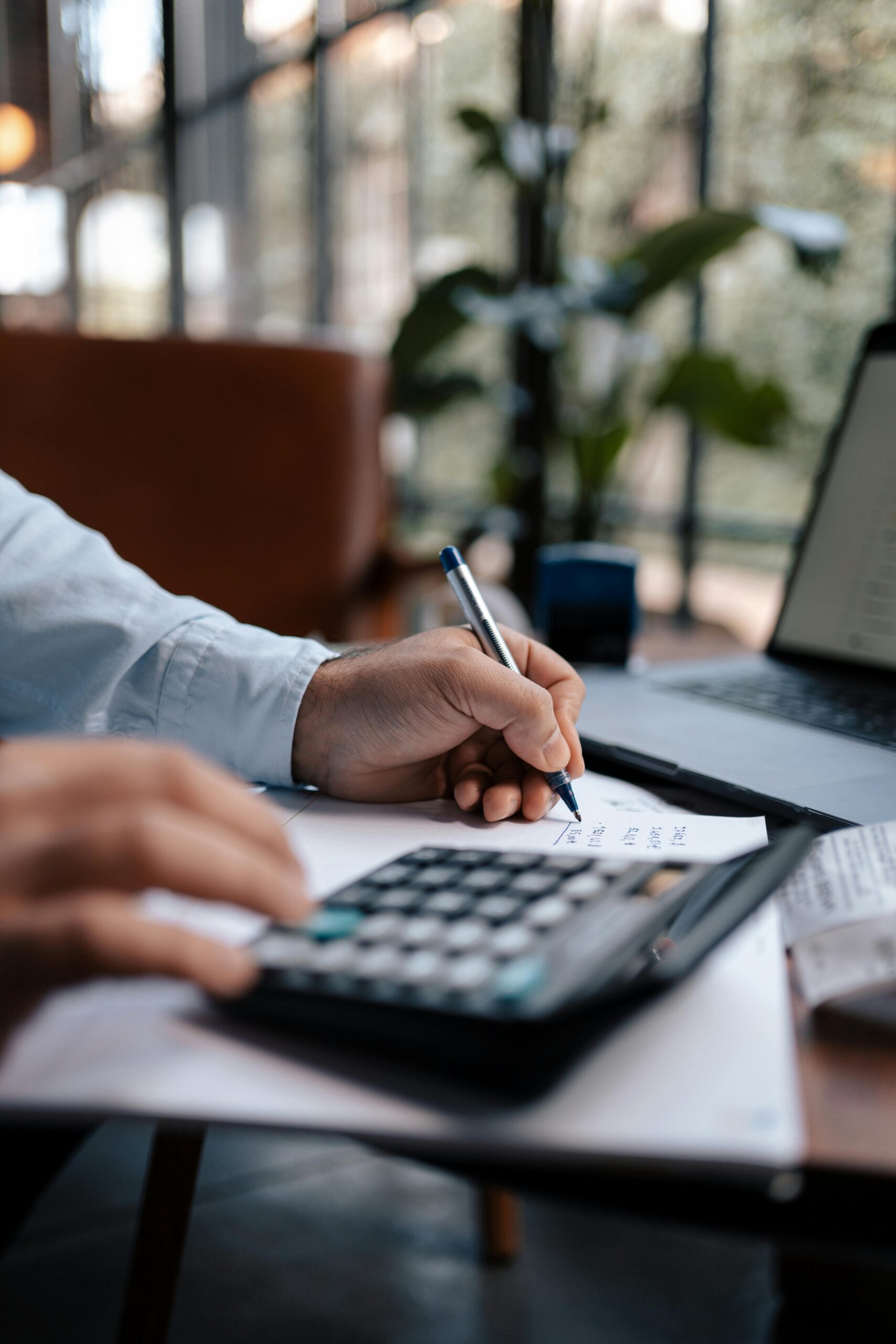 part time job part 2 managing finances A person using a calculator and writing down on a piece of paper