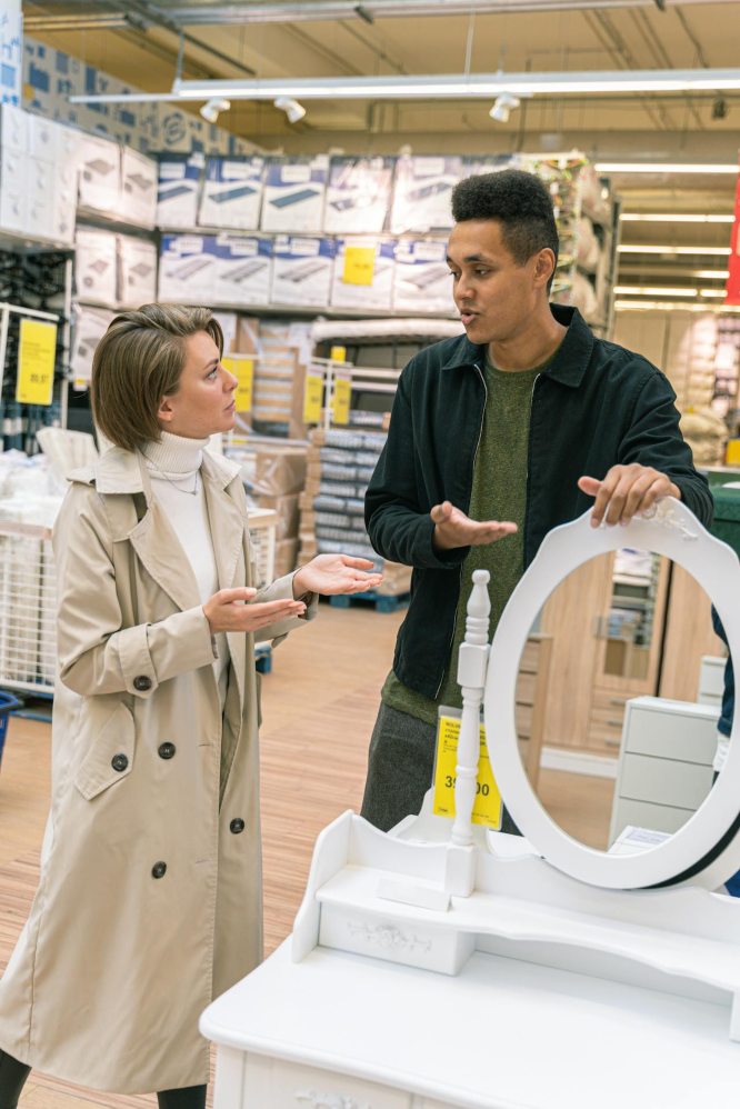 showroomwork a worker in a show room showing a woman a mirror to buy