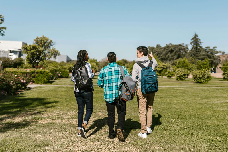 3 college students walking on a field