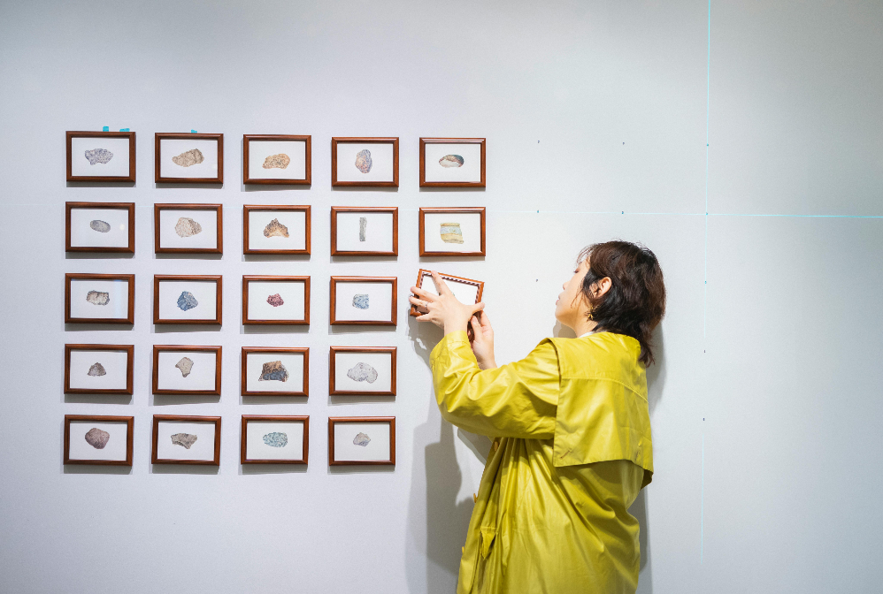a curator hanging a photo on the wall