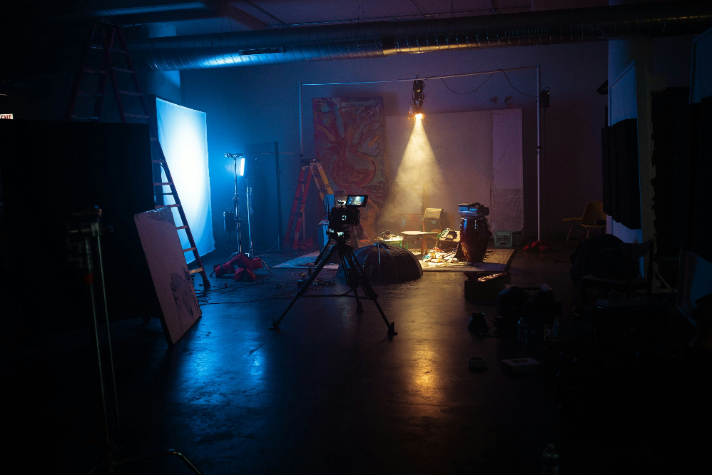 a dark room with white curtains and spotlights