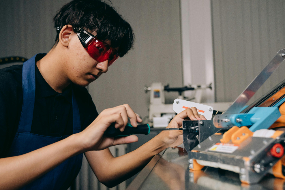 a boy working on with a machine