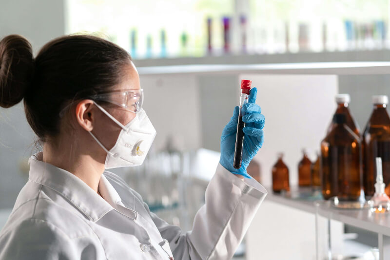 woman-holding-a-blood-sample Female chemist analysing a sample of blood in a test tube