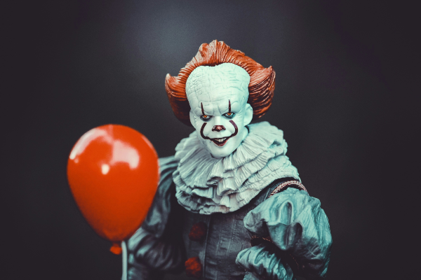 halloween1 pennywise holding a balloon standing in front of a black background