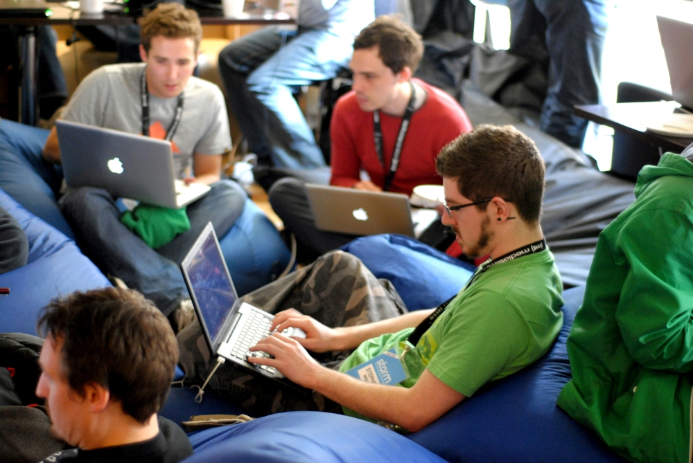 networking image A group of young people sat on comfortable low chairs on laptops.