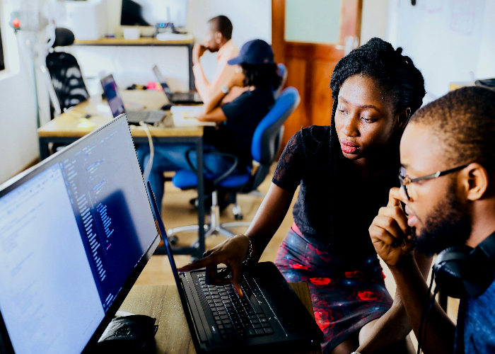 a man and a woman sitting staring at a computer screen