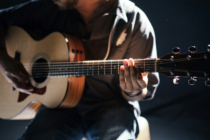 a man seated playing a guitar